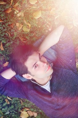 Genç bir adam öğle yemeği zamanında parkta yürür. Bir adam yürüyüşe çıktı. 