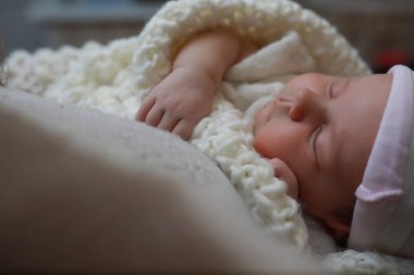 Yeni doğmuş bebek battaniyeye sarılmış uyuyor