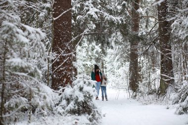 Genç bir aile yürüyüşe çıktı. Anne ve kızı şarapla yürüyorlar.