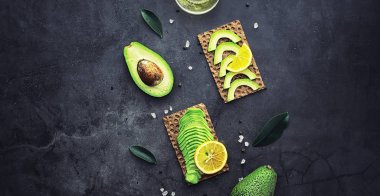 Avokado yemek tarifleri. Olgun yeşil avokado ahşap bir kesim üzerinde 