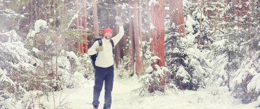 Bir adam sırt çantasıyla seyahat eder. Ormanda kış yürüyüşü. Touris