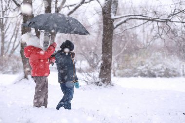 Çocuklar parkta ilk kar yürümek