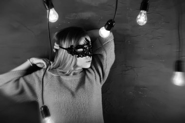 Siyah bir maske içinde sarı saçlı bir kızla