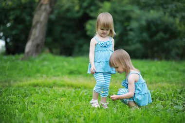 Parkta yürüyen iki ikiz kız.