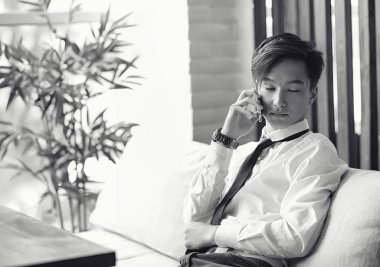 Genç Asyalı işadamı bir kafede bir ortak için bekliyor. Bu