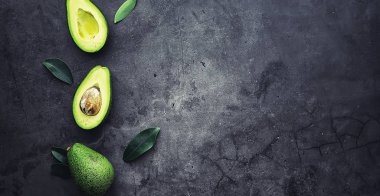 Avokado yemek tarifleri. Olgun yeşil avokado ahşap bir kesim üzerinde 