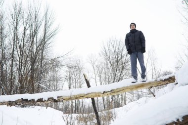 Kışın ormanda bir adam. Sırt çantalı bir turist.