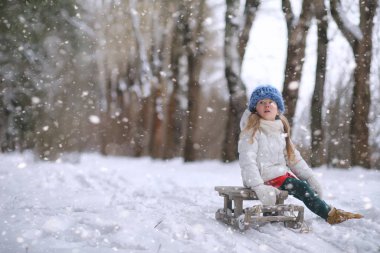 Bir kış masal, genç bir anne ve kızı bir kızak sürmek