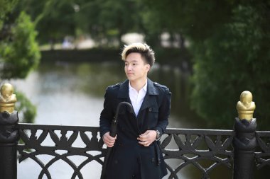 Bahar yağmurlu hava ve bir şemsiye ile genç bir adam