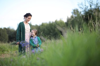 Anne ve kızı yolda yürüyor.
