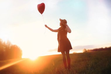 Parkta bir yürüyüş üzerinde şapkalı bir kız. Bir kızla bir sepet yürüyüş