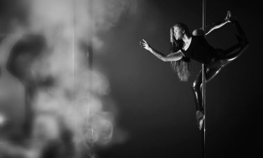 Spor aletleri üzerinde egzersiz yapan bir kız. Stüdyodaki direğin üstündeki dansçı..