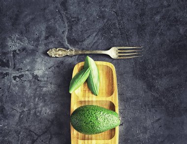 Avokado yemek tarifleri. Olgun yeşil avokado ahşap bir kesim üzerinde 