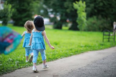 Parkta yürüyen iki ikiz kız.