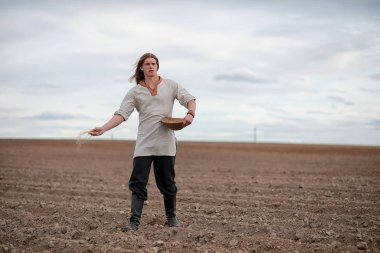 Genç bir köylü tahıl alanıyla sows