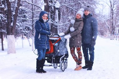 Puseti olan arkadaşlar kış parkında yürüyor. 