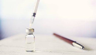 Bir adam tıbbi belge imzalıyor. Tıbbi malzemeler masada.. 