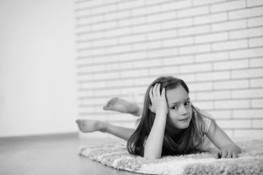 Yerde yatan küçük kız siyah beyaz