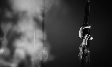 Spor aletleri üzerinde egzersiz yapan bir kız. Stüdyodaki direğin üstündeki dansçı..