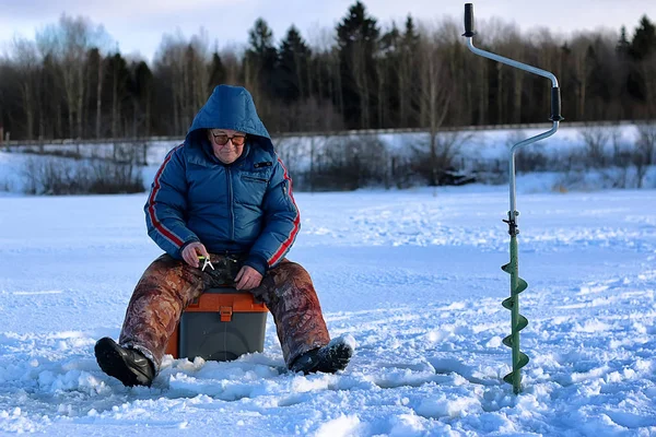 Anciano pescando en el invierno en el lago — Foto de Stock