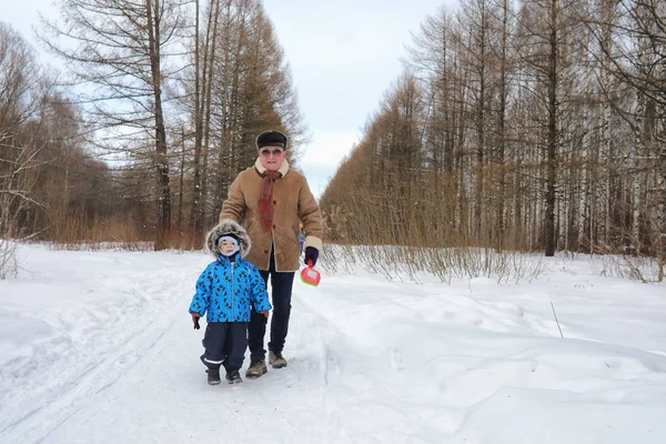 Il bambino con la famiglia si diverte in un parco invernale — Foto Stock