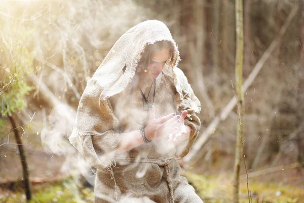 Un uomo con una tonaca trascorre un rituale in una foresta oscura — Foto Stock