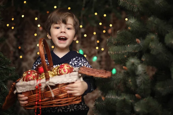 Un niño pequeño junto al árbol de Año Nuevo. Los niños decoran el Chris — Foto de Stock