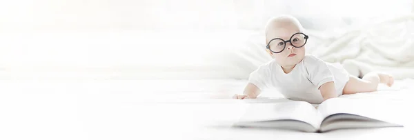 Yeni doğmuş bir bebek yumuşak bir yatakta gözlüklerle yatıyor.. — Stok fotoğraf