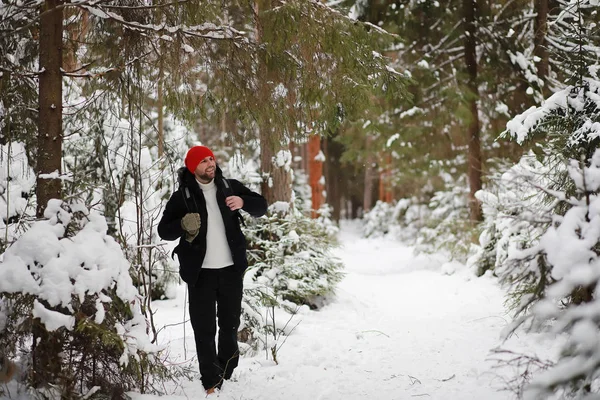 Ein Mann ist mit einem Rucksack unterwegs. Winterwanderung im Wald. Tourismus — Stockfoto