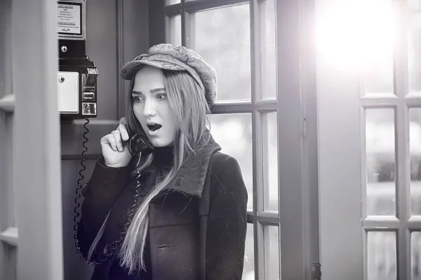 Gyönyörű fiatal lány egy telefon bódé. A lány beszél a th — Stock Fotó