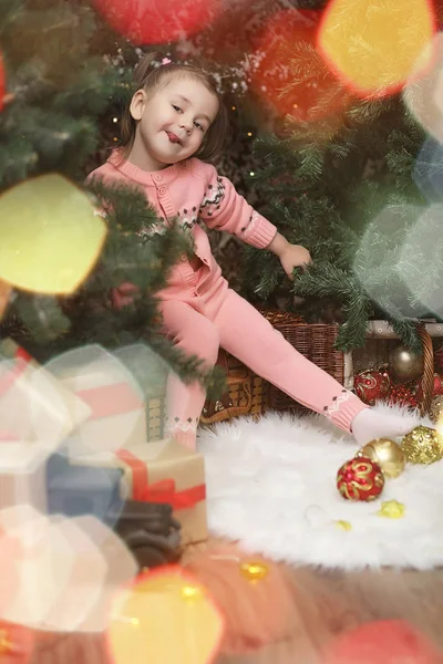 Niña en el ambiente navideño de año nuevo. La chica es feliz. — Foto de Stock