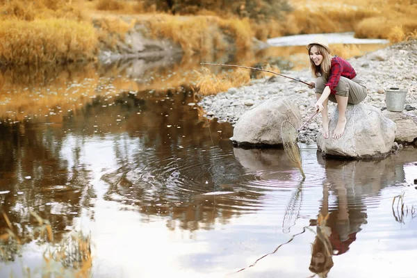 Chica en otoño con una caña de pescar — Foto de Stock