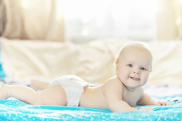 A newborn baby is lying on a soft bed.