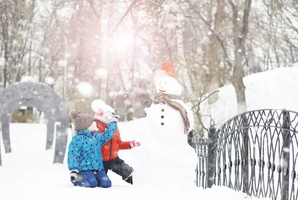 Kışın parktaki çocuklar. Çocuklar oyun oynarken karla oynuyor. — Stok fotoğraf