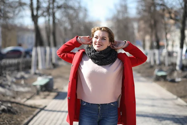 Vacker flicka på en promenad i röd kappa i staden — Stockfoto