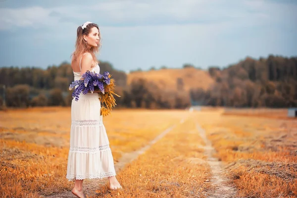 Girl with a bouquet of flowers in autumn — Stock Photo, Image