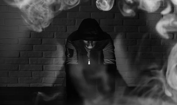 Haker w czarna maska i kaptur na stole — Zdjęcie stockowe