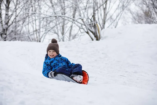 Children in the park in winter. Kids play with snow on the playg — Stock Photo, Image