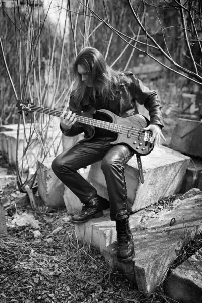 Rockgitarrist utomhus. En musiker med en basgitarr i en leath — Stockfoto