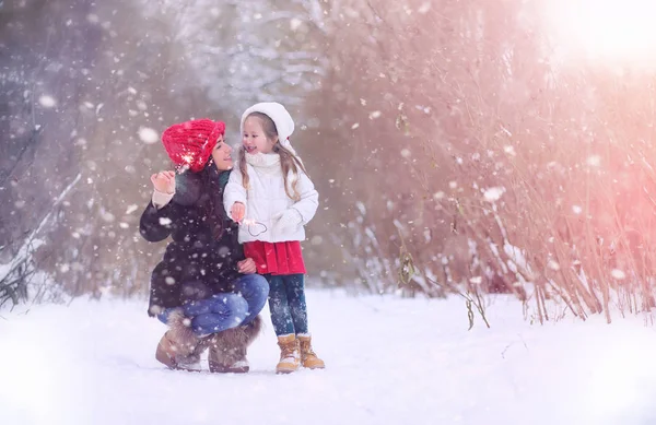 Um conto de fadas de inverno, uma jovem mãe e sua filha montam um trenó — Fotografia de Stock