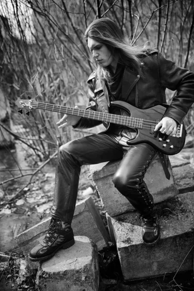 Rockgitarist buiten. Een muzikant met een basgitaar in een leath — Stockfoto
