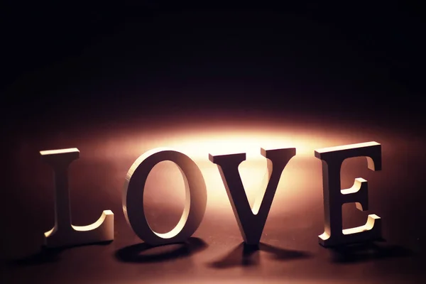 Letras de madera y metal que forman la palabra LOVE escrita en negro oscuro — Foto de Stock