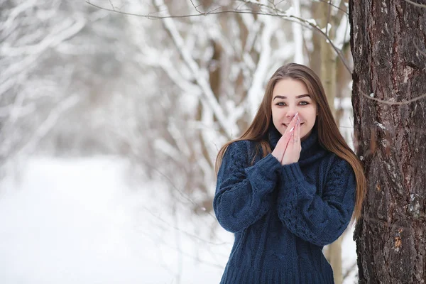 Una joven en un parque de invierno en un paseo. Vacaciones de Navidad en t —  Fotos de Stock