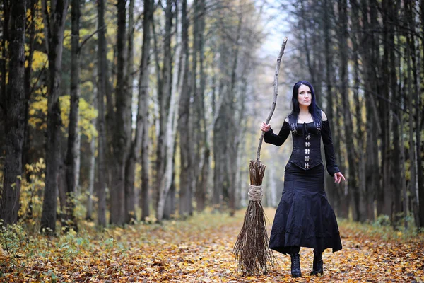 Una donna in abito da strega in una foresta — Foto Stock