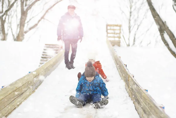Dzieci w parku zimą. Dzieci bawią się śniegiem na zabawie — Zdjęcie stockowe