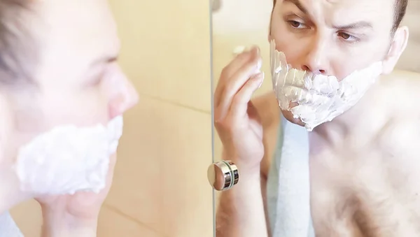 Чоловік голить у ванній вранці — стокове фото