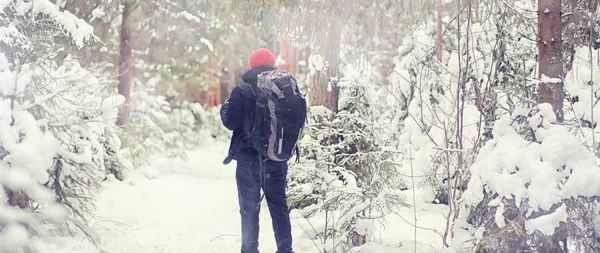 Een man reist met een rugzak. Winterwandeling in het bos. Toerisme — Stockfoto