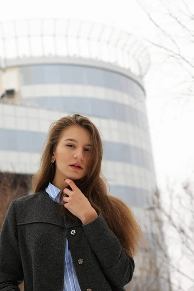 Giovane ragazza adulta in cappotto sulla strada — Foto Stock