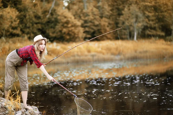 Ragazza in autunno con una canna da pesca — Foto Stock