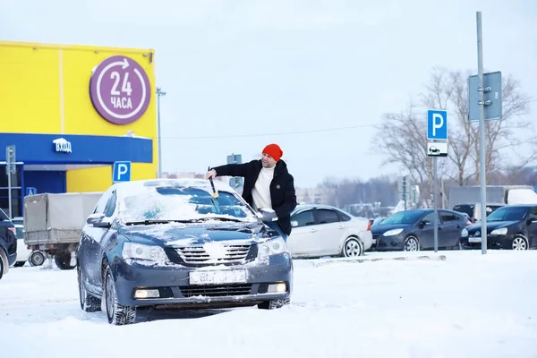 Un conductor masculino está parado frente a un coche. El propietario limpia th — Foto de Stock